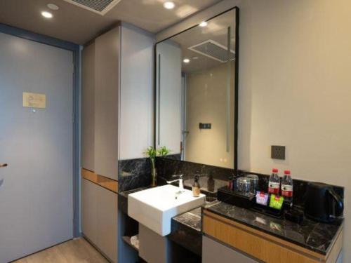 a bathroom with a sink and a mirror at Home Inn Kunming Baita Road in Kunming
