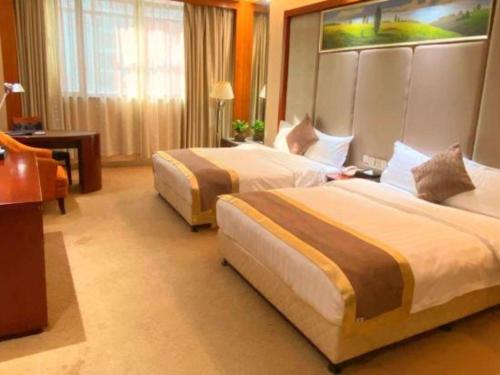 a hotel room with two beds in a room at Jie Hao Royal Hotel in Shenzhen