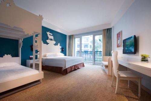 a bedroom with two beds and a desk and a window at Oasis O.City Hotel in Shenzhen