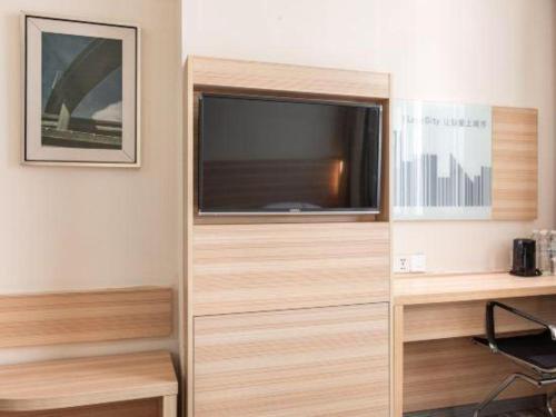 a living room with a flat screen tv in a room at City Comfort Inn Xiangyang Railway Station in Xiangyang