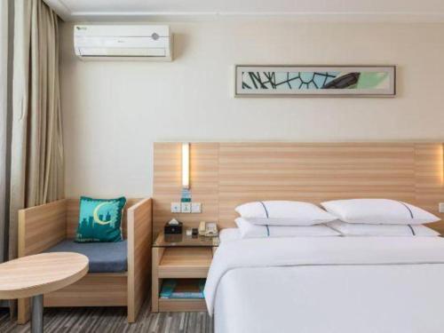 襄阳City Comfort Inn Xiangyang Railway Station的一间卧室，配有一张床、一张桌子和一张书桌