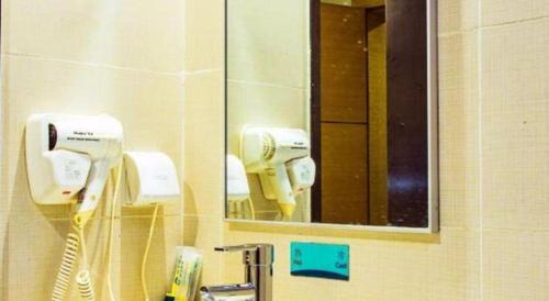 a bathroom with two hair dryers and a mirror at City Comfort Inn Guilin Xing'an in Xing'an