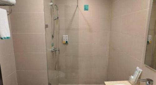 a shower with a glass door in a bathroom at City Comfort Inn Guilin Xing'an in Xing'an