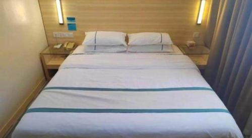 a large white bed in a hotel room at City Comfort Inn Guilin Xing'an in Xing'an
