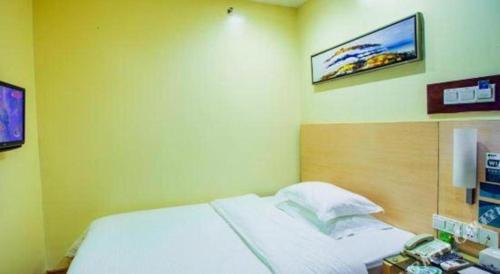 a bedroom with a bed and a tv on the wall at City Comfort Inn Guilin Xing'an in Xing'an