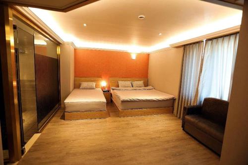 a small room with two beds and a couch at Jeju Sejong Hotel in Jeju