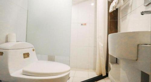 a white bathroom with a toilet and a sink at Beijing Inner Mongolia Hotel Chaoyang in Beijing