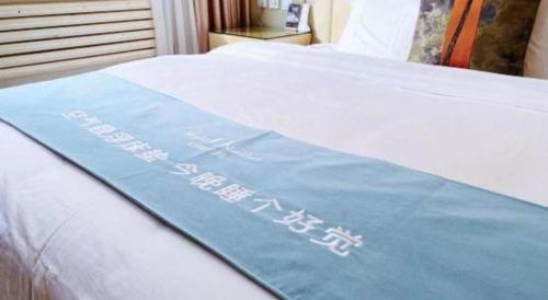 a sign on a bed with a sign on it at Beijing Inner Mongolia Hotel Chaoyang in Beijing