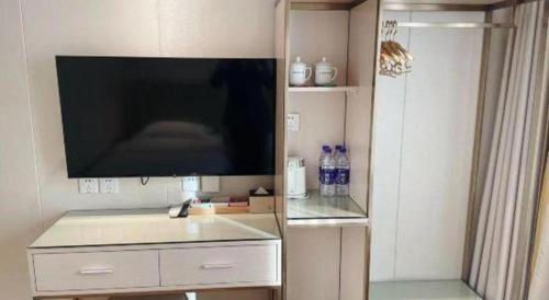 a living room with a flat screen tv on a wall at Beijing Inner Mongolia Hotel Chaoyang in Beijing