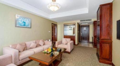 a living room with a couch and a table at Chinflux Mandarin Hotel in Dongguan