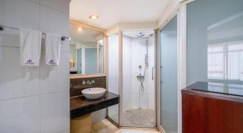 a bathroom with a shower and a sink at Chinflux Mandarin Hotel in Dongguan