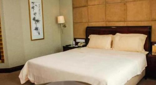 a bedroom with a large white bed in a room at Chinflux Mandarin Hotel in Dongguan