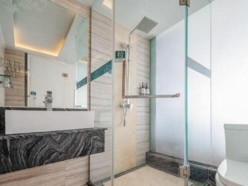 a bathroom with a shower and a sink and a toilet at Shanshui Fashion Hotel Shunde Ronggui Branch in Shunde