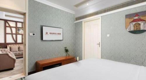 a bedroom with a bed and a living room at Zaozhuang Hotel in Zaozhuang