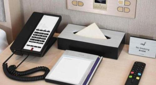 a desk with a cell phone and a cash register at Lavande Hotel·Dongxing Port in Fangcheng