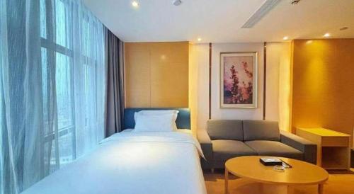 a hotel room with a bed and a couch at Lavande Hotel·Dongxing Port in Fangcheng