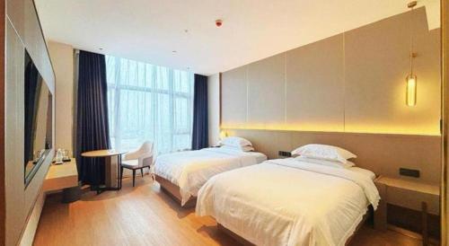 a hotel room with two beds and a table at Lavande Hotel·Dongxing Port in Fangcheng