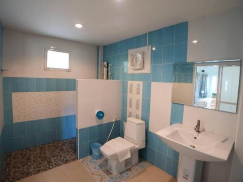 La salle de bains est pourvue de carrelage bleu, d'un lavabo et de toilettes. dans l'établissement Chiangkhan Gallery Resort, à Chiang Khan