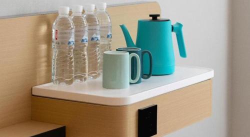 a shelf with water bottles and cups on it at City Comfort Inn Wuhan Hankou Railway Station West Square in Wuhan