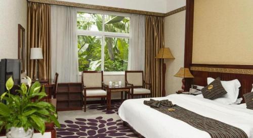 ein Hotelzimmer mit einem Bett, einem Tisch und einem Fenster in der Unterkunft Shangri-La Original Density Hotel in Shangri-La