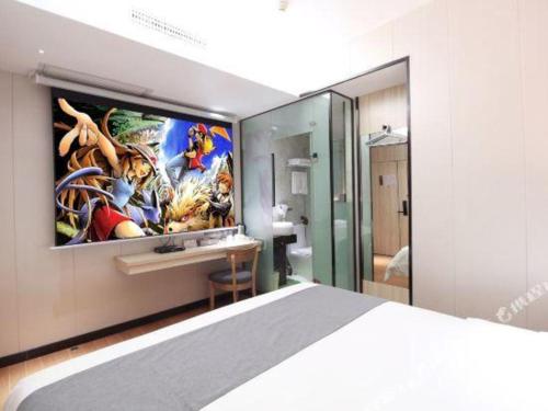 a bedroom with a large tv on the wall at Wenxing Hotel Guangzhou Gangding Metro Station Branch in Guangzhou
