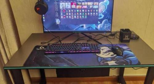 a computer monitor and a keyboard and mouse on a table at Oriental Hotel in Dongguan