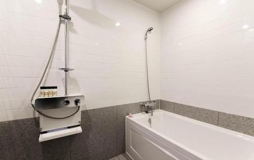 a bathroom with a bath tub and a sink at Gimhae Perfect Hotel in Gimhae