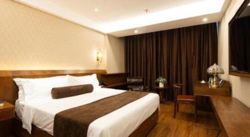 a hotel room with a large bed and a desk at James Joyce Coffetel Tianjin Railway Station Jinshiqiao Metro Station Branch in Tianjin