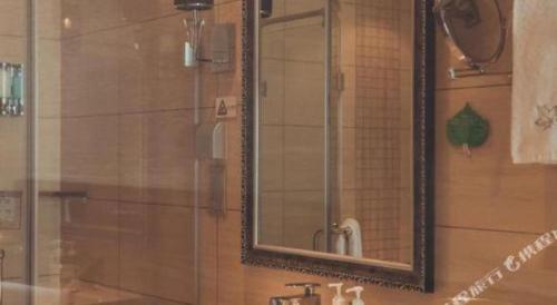 a mirror over a sink in a bathroom at Kunming Wenhui Hotel in Kunming