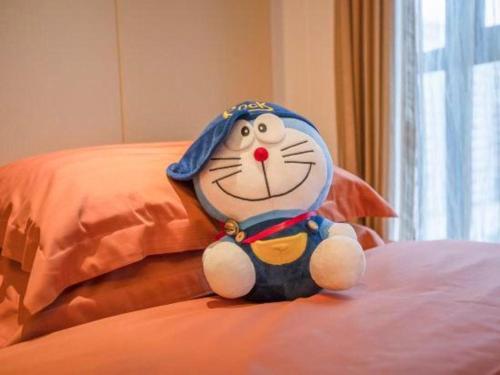 a stuffed cat toy sitting on a bed at Fortune International Hotel in Xiawutun