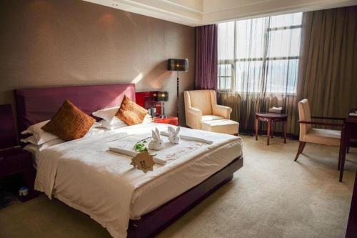 a hotel room with a large bed and a living room at Kunming Wenhui Hotel in Kunming