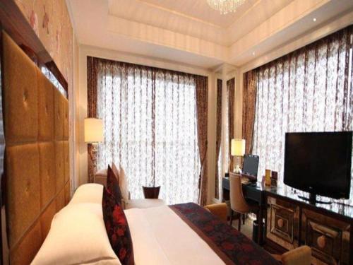a hotel room with a bed and a desk and a television at Fortune International Hotel in Xiawutun