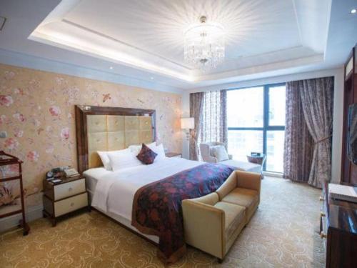 a large bedroom with a large bed and a chair at Fortune International Hotel in Xiawutun