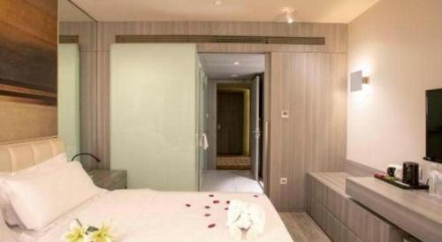 a bedroom with a white bed with flowers on it at Jinjiang Metropolo Hotel - Qingdao Chengyang District Government in Qingdao