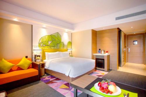 a hotel room with a bed and a couch at Hampton by Hilton Xi'an Dayan Pagoda in Xi'an