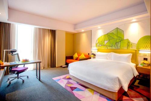 a hotel room with a large bed and a desk at Hampton by Hilton Xi'an Dayan Pagoda in Xi'an