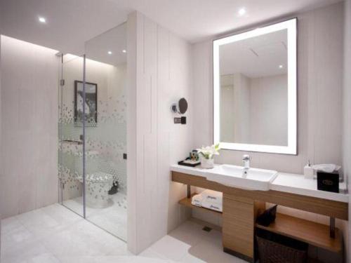 a bathroom with a sink and a shower with a mirror at Hampton by Hilton Xi'an Dayan Pagoda in Xi'an