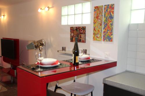 eine Küche mit einer roten Theke und einer Flasche Wein in der Unterkunft Studio 48 in Thessaloniki