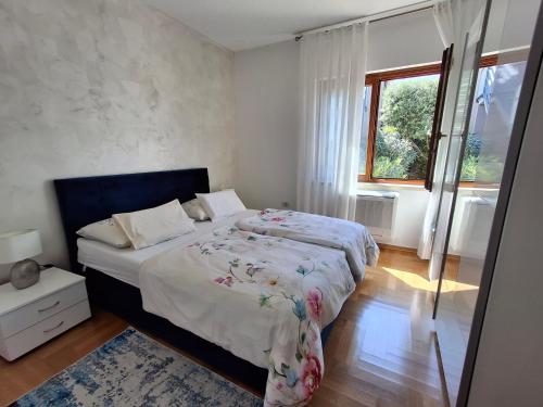 a bedroom with two beds and a window at Apartments Leona in Umag
