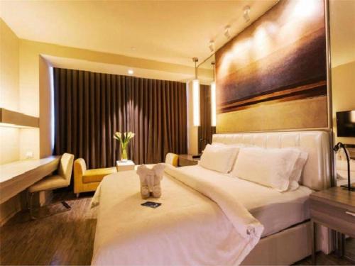 a bedroom with a large bed with a large painting on the wall at Jinjiang Metropolo Hotel - Qingdao Chengyang District Government in Qingdao