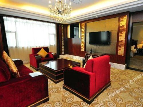 a living room with red furniture and a flat screen tv at Guangzhou Jing Yi hotel in Huadu