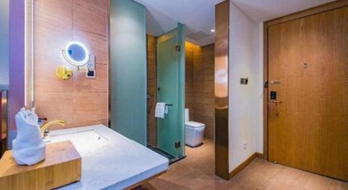 Un baño con ducha, lavabo e inodoro. en James Joyce Coffetel Changsha Wanjiali Baoqiaobei Metro Station, en Changsha
