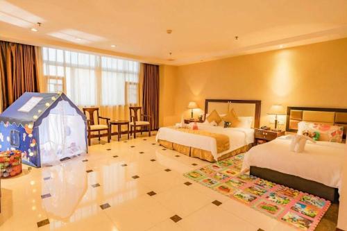 a hotel room with two beds and a play tent at Guangzhou Jing Yi hotel in Huadu
