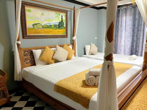 a bedroom with two beds and a painting on the wall at Ladawan Boutique Hotel in Ban Pak Khlong