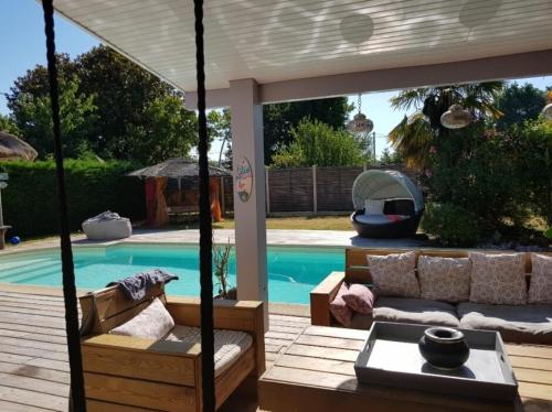 a backyard with a swimming pool and a pergola at La Villa du Teich in Le Teich