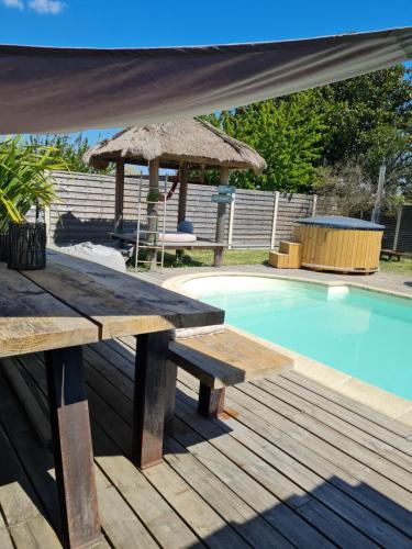 a picnic table and an umbrella next to a swimming pool at La Villa du Teich in Le Teich