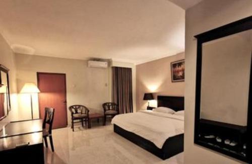 a hotel room with a bed and a flat screen tv at Plaza Hotel Tegal in Tegal