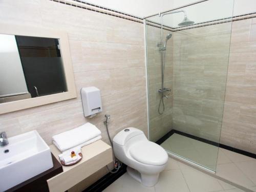 a bathroom with a shower and a toilet and a sink at Plaza Hotel Tegal in Tegal