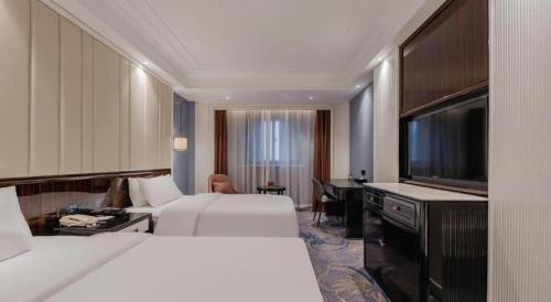 a hotel room with two beds and a flat screen tv at Jinjiang Metropolo Hotel Nanjing Confucius Temple Branch in Nanjing