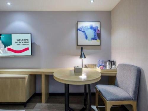 a desk and a chair in a room at Echarm Hotel Beihai Railway Station in Beihai
